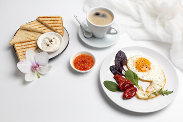 Fried egg on the plate, toasts with sauce and a cup of coffee.