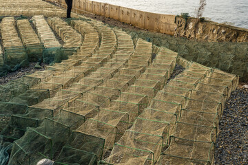 Obraz premium Fishermen's boats and crab fishing traps on the shore in Kep, Cambodia