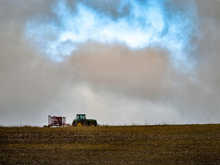 Fototapeta premium Tractor plows ground in big drought, very dry land, spring on the farm