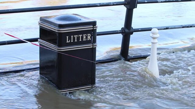 The River Severn flowing past a bin on a footpath after overflowing its banks near Bewdley, Worcestershire. Storm Bert. November 2024. UK