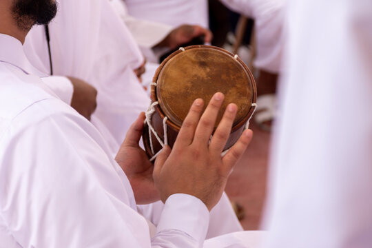 Qatari man drumming on old drums in traditional dance (Al Ardha).