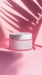A cosmetic cream jar with a blank label, serene pink surface with subtle shadows