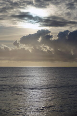 Obraz premium Sunrise over the sea. Light breaks through a strip of clouds. Horizon and sky. 