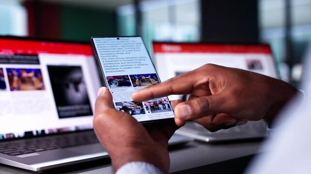 Watching Online News Article On Mobile Phone And Laptop