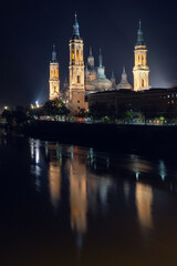 Naklejka premium Illuminated Basilica of Our Lady of the Pillar and Puente de Piedra at Night