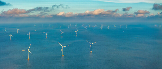 Tall windmill turbines against a clear blue sky, generating renewable energy in the serene Go Cong, Vietnam landscape by the sea. Like windmill park Westermeerdijk in the Noordoostpolder Netherlands.