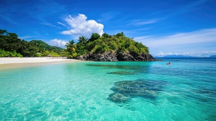 Fototapeta premium Idyllic tropical beach with crystal-clear turquoise water, white sand, lush greenery, and a rocky headland under a vibrant blue sky.