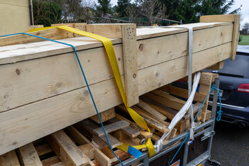 Trailer with lumber wooden boards for the house