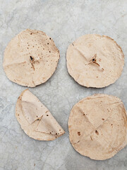 Chapati roti, chapathi, Paratha Indian whole wheat flat bread. Healthy fiber rich traditional North or South food Kerala India. Indian traditional food chapati or roti drying on surface in sunlight.