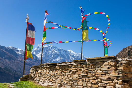 Tibetan Prayer Flags in the Air in front of the Annapurna Himal Mountain Range in Manang, Nepal
