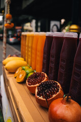 Small local business with a mobile stand in the street to sell fresh tropical fruit juice - pomegranate, tangerine, mango; refreshment concept; Bangkok, Thailand