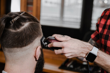 The hands of the hairdresser hold a comb and scissors. Haircut in the hairdresser's.Master...