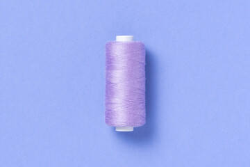 Purple violet thread spool close-up flat lay top view with copy space for text