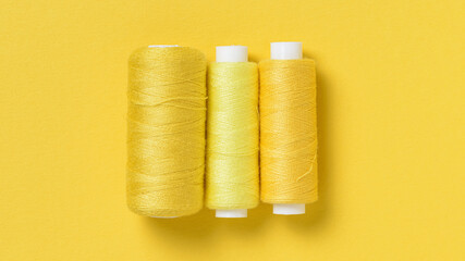 Yellow thread spools background with copy space for text close-up flat lay top view