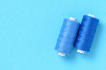 Blue thread spools background with copy space for text close-up flat lay top view