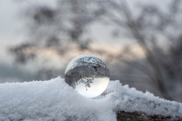 Snow-covered landscape is reflected in a sphere
