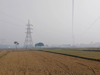  High voltage electric transmission pylon silhouetted tower in agriculture field