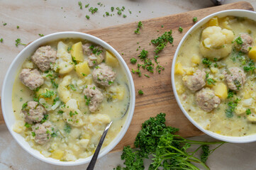 Delicious homemade cooked potato cauliflower soup with meatballs on a plate