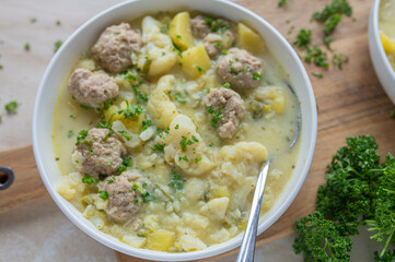 Delicious homemade cooked potato cauliflower soup with meatballs on a plate