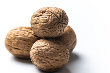Whole walnut, photographed close up, on white surface.
