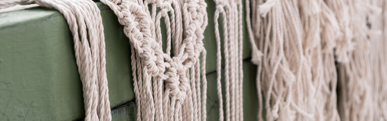 Woman weaves home Handmade decor from cotton thread macrame. Macrame panel creating process. Banner