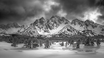 Majestic snow-covered mountains under a dramatic cloudy sky in winter