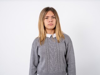 Displeased Beautiful teenager girl wearing sweater over dress shirt frowns face feels unhappy has...