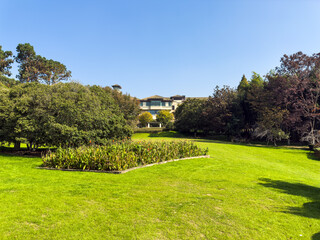 Lush Green Garden Surrounded by Vibrant Flora and Architecture