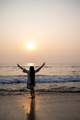 Fototapeta premium strong confidence woman open arms under the sunrise or sunset at seaside