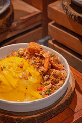 High angle, Creamy omelet with deep-fried seafood, chili and salt served with rice on dish, place on wooden board