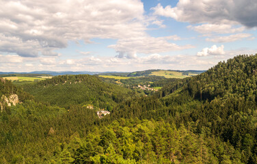 Obraz premium Picturesque countryside view with a small village nestled in a green valley, surrounded by hills