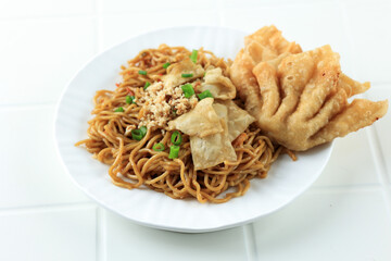 Close Up Mie Gacoan, Popular Spicy Indonesian Fried Noodle with Fried Dumpling.