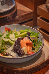 Rocket salad, include smoked salmon, avocado, lettuce, tomato and italian sauce on bowl, place on wooden serving board