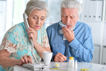 An elderly couple is sick and takes medication at home