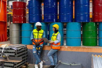 Experienced female supervisor in safety vest is sharing her advice to an African mechanical...