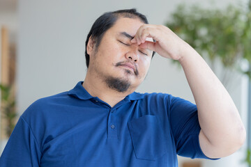 Stressful overworked middle aged old asian man suffering from headache, health and sickness concept...