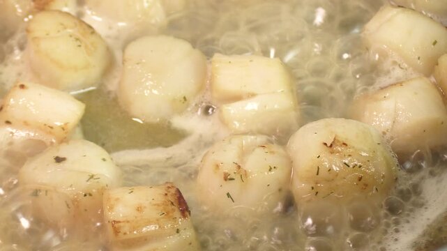 saint-jacques et bouillon, en gros plan, en cuisson dans une po&ecirc;le
