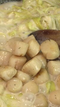 Saint-Jacques au poireaux, en cuisson, dans une po&ecirc;le