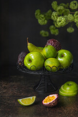 Patera zielonych owoców na ciemnym tle