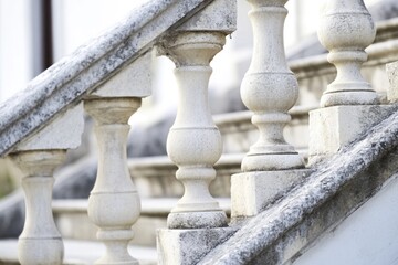 Fototapeta premium A close-up shot of a railing with a bird sitting on top, possibly in a park or garden setting