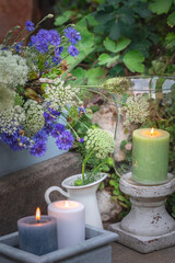 Letnia kompozycja ogrodowa z kwiatów, roślin i świec. Naturalna, zielono-niebieska © Dorota