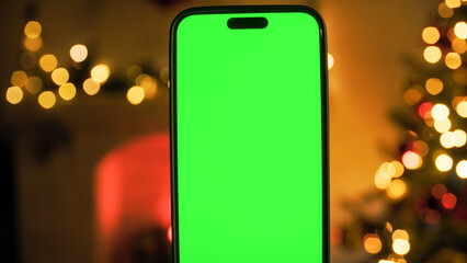 smartphone with green screen in a Christmas room