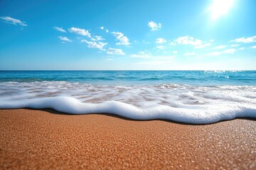 Soft wave crashing on sandy beach under blue sky and shining sun