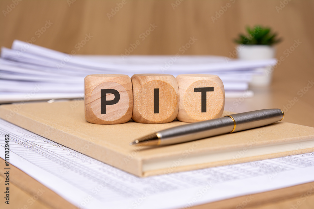 Poster wooden blocks displaying various letters on top of documents along with a pen for writing