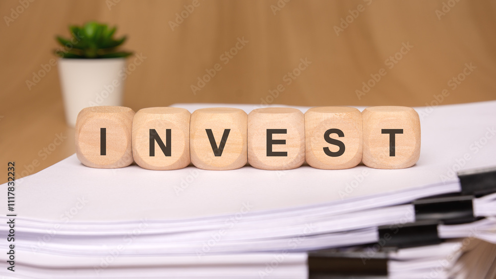 Poster this concept involves thoughtful investment using wooden blocks on a backdrop of paperwork