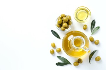 Bottle of fresh olive oil and olives with leaves on white background