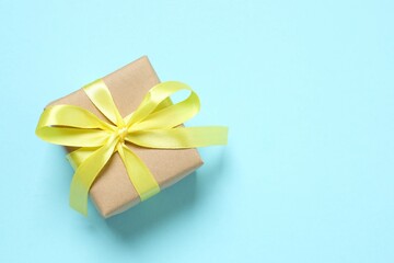 Beautiful gift box tied with bow on color background 