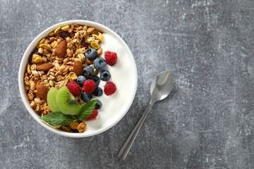Delicious granola with berries and yogurt on a light background