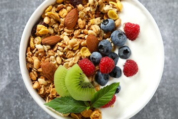 Delicious granola with berries and yogurt on a light background
