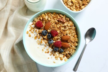 Delicious granola with berries and yogurt on a light background